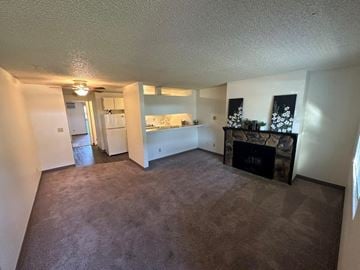 Kennewick apartment for rent - A living room with a fireplace and a painting on the wall.