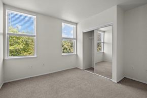 Portland apartment for rent - Bedroom with spacious closet, large windows, and white walls at Collins Circle Apartments in Portland, Oregon.