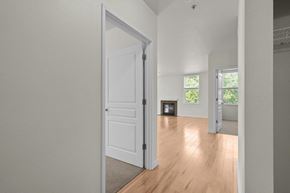 Portland apartment for rent - Hallway view into living room with white walls and wood-style flooring at Collins Circle apartments in the Goose Hollow district in Portland, Oregon.