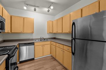 Portland apartment for rent - a kitchen with stainless steel appliances and wooden cabinets