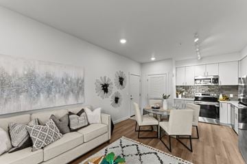 Spokane apartment for rent - A modern living room with a large painting on the wall and a kitchen area in the background.