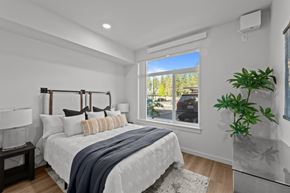 Spokane apartment for rent - A bedroom with a large bed and a window overlooking a street.