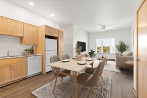 Seattle apartment for rent - A modern kitchen with wooden cabinets and a dining table set for four.