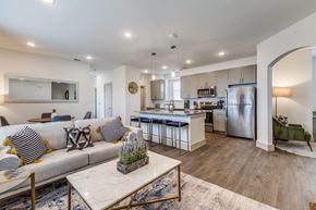 Rockwall apartment for rent - A modern kitchen with a breakfast bar and a living room with a sofa.