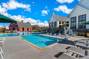 Cane Ridge apartment for rent - A large swimming pool with lounge chairs and a white building in the background.