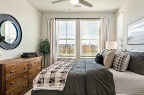 Cane Ridge apartment for rent - A bedroom with a large bed and a mirror on the wall.
