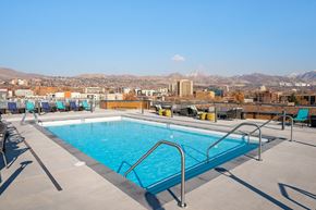Salt Lake City apartment for rent - A swimming pool on a rooftop with mountains in the background.