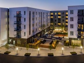 Portland apartment for rent - A modern building complex with a courtyard and trees.