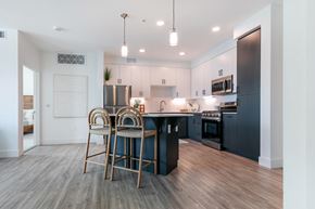Irvine apartment for rent - A modern kitchen with a bar stool and a dining table.