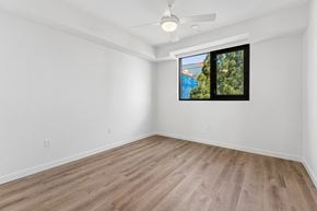 San Diego apartment for rent - A room with a ceiling fan and a window overlooking a pool and trees.