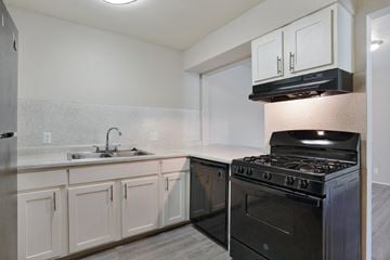 Murray apartment for rent - A kitchen with a black stove and white cabinets.