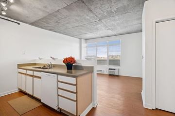 Denver apartment for rent - A kitchen with white cabinets and a wooden island.