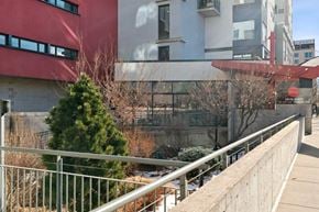 Denver apartment for rent - A building with a red and white exterior and a tree in front of it.