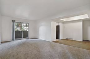 Holladay apartment for rent - A spacious room with a carpeted floor and a sliding glass door.