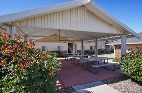 Ogden apartment for rent - A covered patio area with tables and benches.