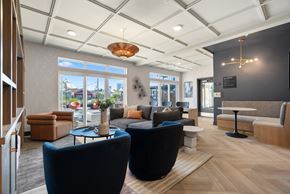 Denver apartment for rent - A modern waiting room with blue chairs and a wooden floor.