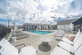 Liberty Lake apartment for rent - A pool area with white chairs and a table.