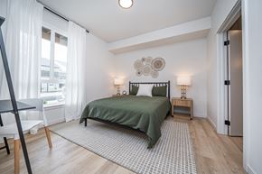 Liberty Lake apartment for rent - A bedroom with a bed, nightstand, and chair.