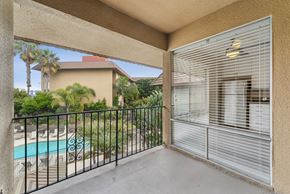 San Diego apartment for rent - A balcony with a pool and palm trees in the background.