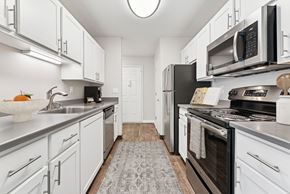 Portland apartment for rent - A modern kitchen with white cabinets and stainless steel appliances.