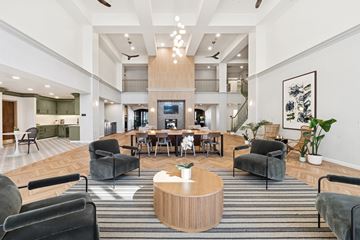 Dallas apartment for rent - A modern living room with a wooden coffee table and grey chairs.