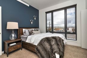 Portland apartment for rent - a bedroom with a large window and a bed with a wooden headboard