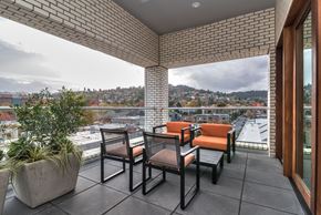 Portland apartment for rent - A patio with a table and chairs overlooking a city.