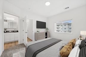 Gillette apartment for rent - A modern bedroom with a large bed and a flat-screen TV.