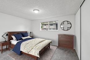 Springfield apartment for rent - A bedroom with a bed, nightstand, and a window with a view of a building outside.
