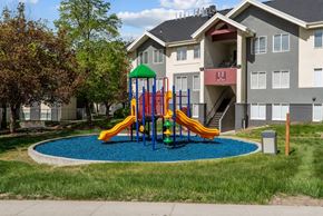 Salt Lake City apartment for rent - A playground with a yellow slide in front of a building.