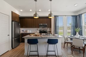 Pflugerville apartment for rent - A modern kitchen with dark wood cabinets and a large island.