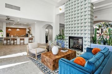 Gilbert apartment for rent - A living room with a blue couch and a fireplace.