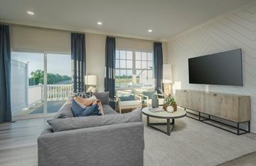 White Plains apartment for rent - A modern living room with a grey sofa and a flat screen TV mounted on the wall.