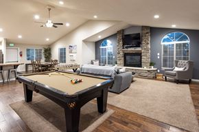 Spokane Valley apartment for rent - A pool table is in the middle of a room with a fireplace and a couch.