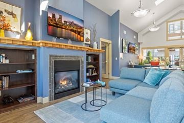 Beaverton apartment for rent - A living room with a fireplace and a painting of a city skyline on the wall.