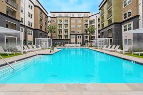 Irvine apartment for rent - A large swimming pool in front of apartment buildings.