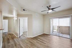Tucson apartment for rent - A room with a ceiling fan and sliding glass doors.