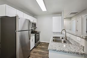 Tucson apartment for rent - A kitchen with a stainless steel refrigerator, microwave, and oven.