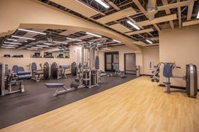 Tucson apartment for rent - A gym with a variety of equipment including weights and machines.