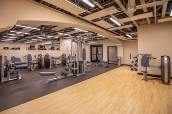 Split-level gym with adjacent shower rooms, bottle-filling station, lockers, and storage rooms