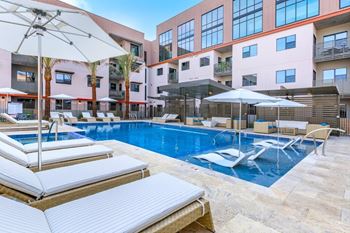 Fenced pool with lagoon, hot tub, bbq area with bar seating, lounge seating, fire pits, ramadas, water curtain feature, and pool house