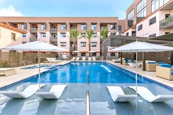 Fenced pool with lagoon, hot tub, bbq area with bar seating, lounge seating, fire pits, ramadas, water curtain feature, and pool house
