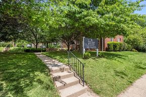 Arlington apartment for rent - A sign in a park with a staircase leading to a building.