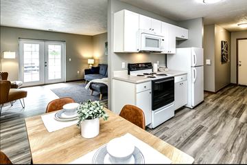 La Vista apartment for rent - A modern kitchen with white appliances and a dining table set for two.