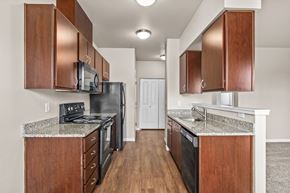 Salem apartment for rent - Galley kitchen with wood cabinets and granite countertops at Fruitland Meadow Apartments, Salem, OR 97317
