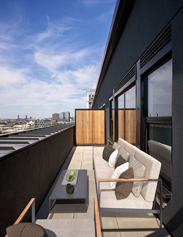 Portland apartment for rent - a living room with a couch and a coffee table on a balcony