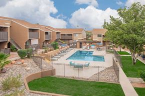 Tucson apartment for rent - A swimming pool surrounded by a fence and chairs.