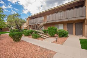 Tucson apartment for rent - A building with a balcony and stairs leading to it.