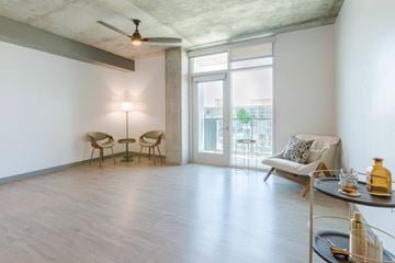 Tucson apartment for rent - A living room with a ceiling fan, two chairs, a sofa, and a table with a bottle on it.