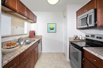 Jessup apartment for rent - A kitchen with brown cabinets and a white fridge.